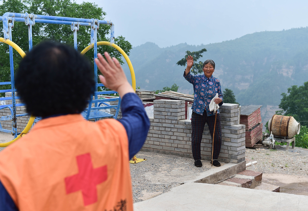7月7日，在山西省阳城县人参�按澹�栗红连（左）跟理完发的老人道别。