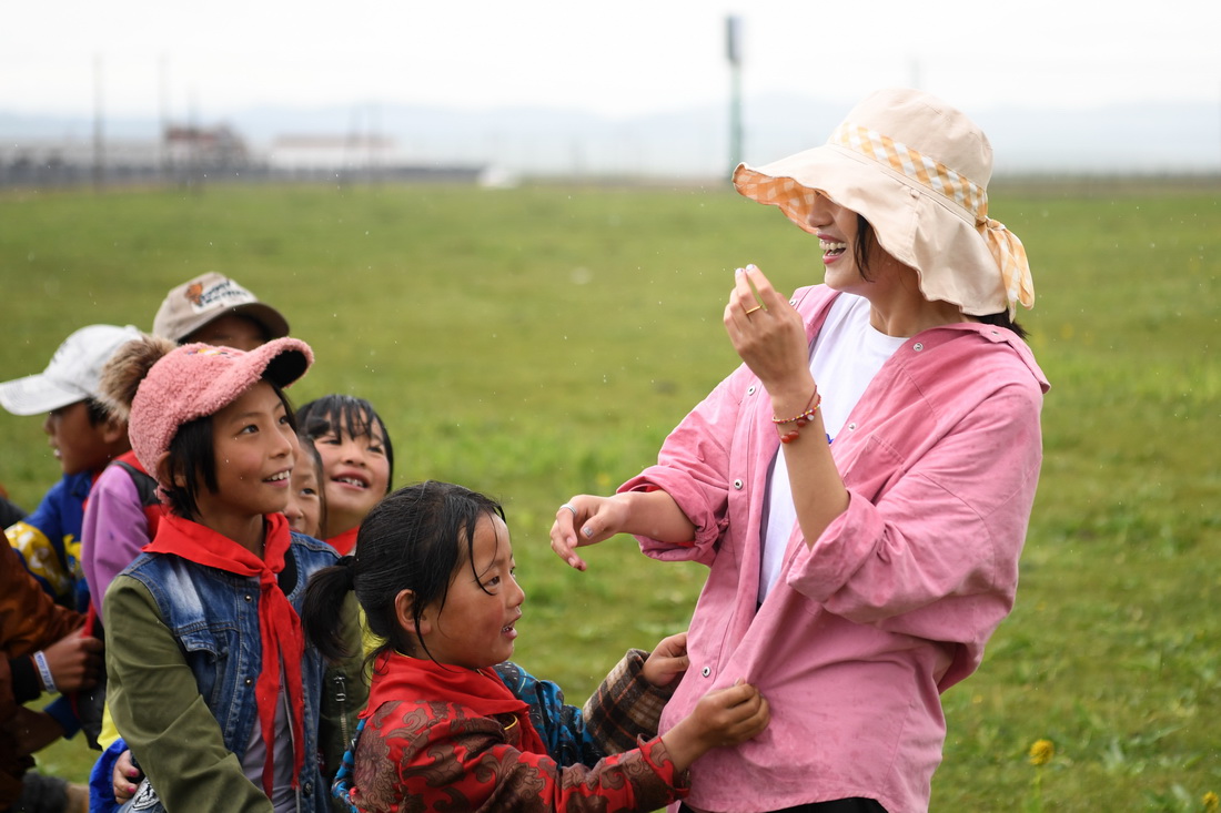 7月14日，河曲馬場小學老師余妙妍（右一）在草原上和孩子們做游戲。