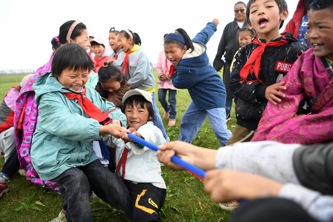 7月14日，河曲馬場小學的孩子們在草原上進行拔河比賽。