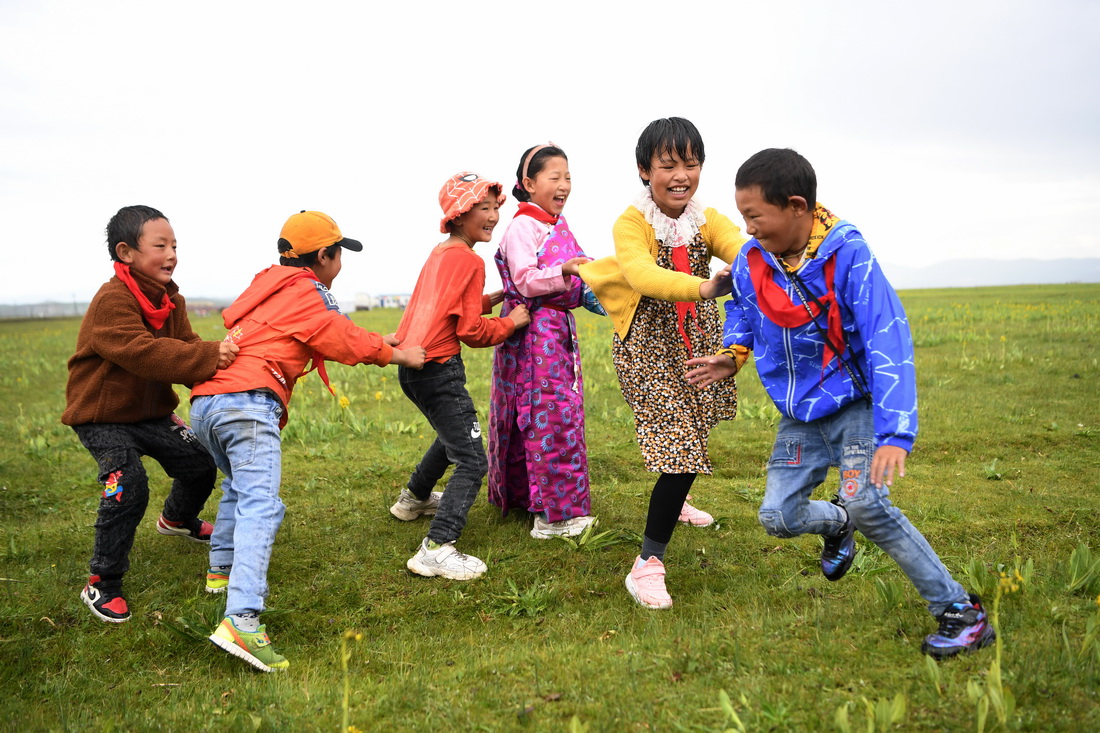 7月14日，河曲馬場小學的孩子們在草原上做游戲。