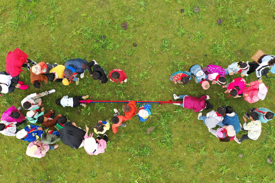 7月14日，河曲馬場小學的孩子們在草原上進行拔河比賽（無人機照片）。