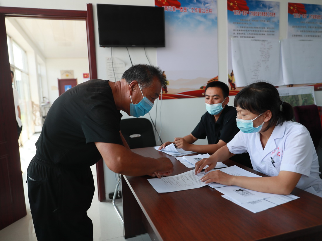 7月19日，在遼寧省遼陽市遼陽縣小北河鎮郭家村，醫護人員對村民進行接種前詢問和登記。