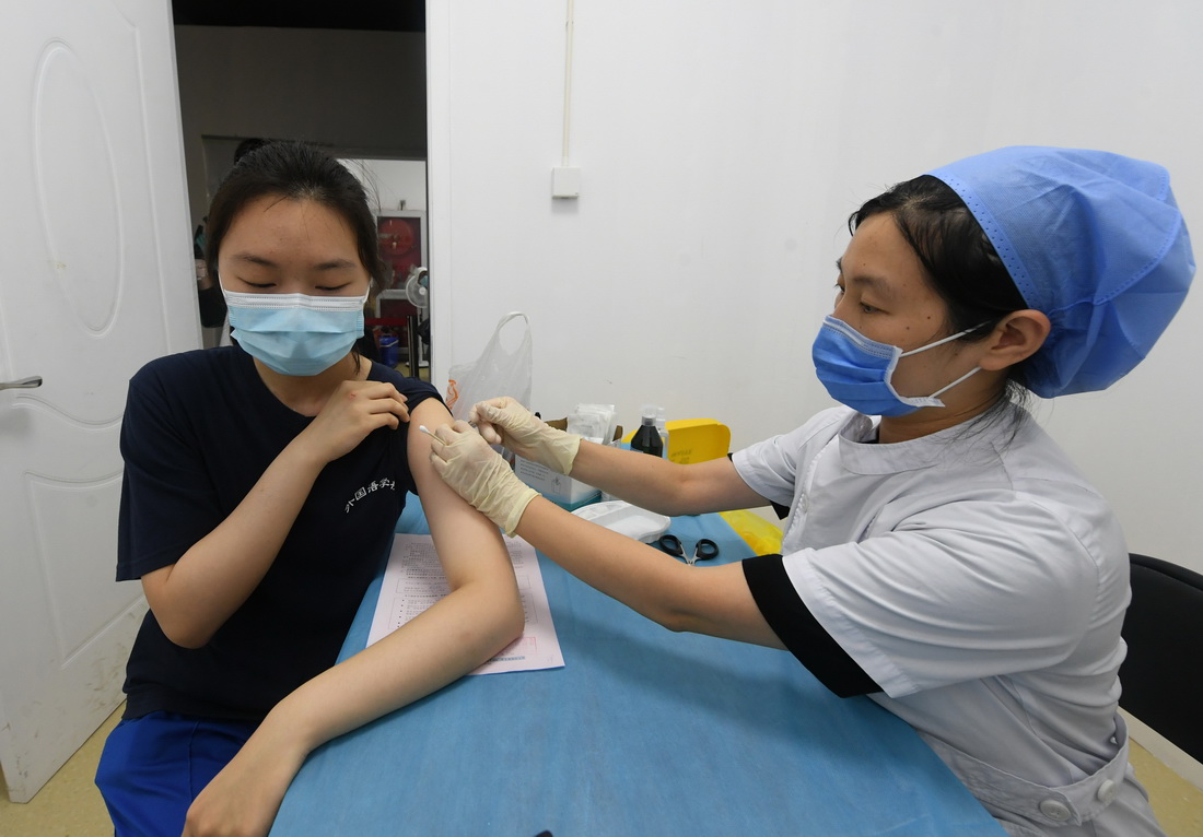 7月21日，在北京市西城區展覽路街道新冠疫苗接種點未成年人接種處，醫護人員為一名高中生接種新冠病毒疫苗。新華社記者 任超 攝