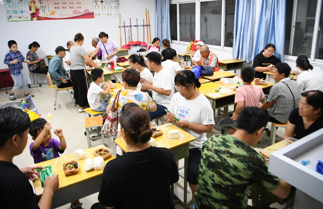 7月21日，轉移群眾在鄭州市電子信息工程學校集中安置點吃晚飯。