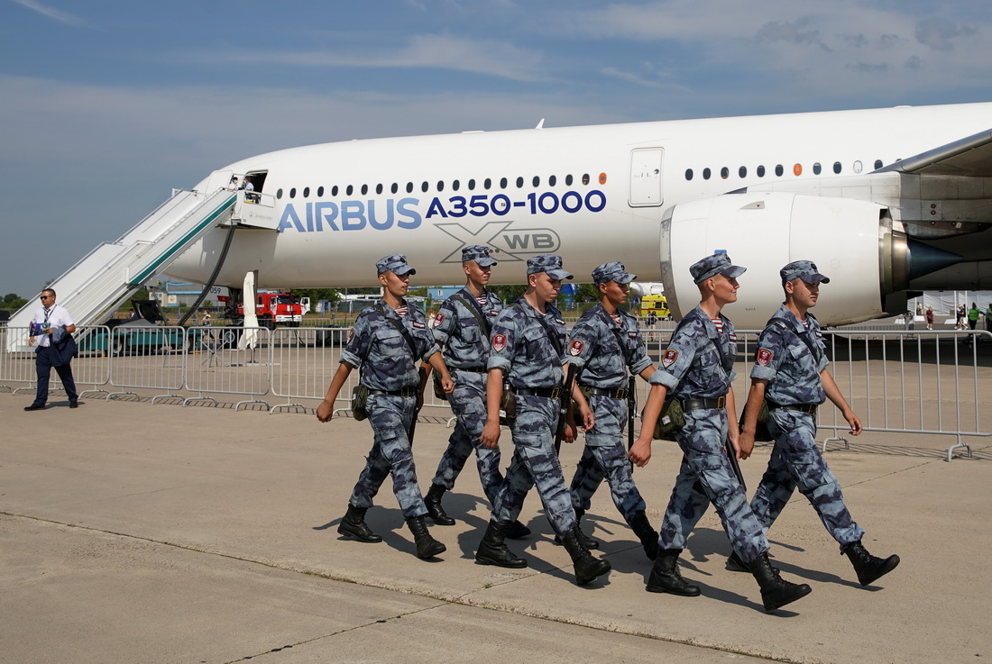 7月20日，在俄羅斯茹科夫斯基市舉行的莫斯科航展上，一隊士兵走過一架客機。新華社/路透