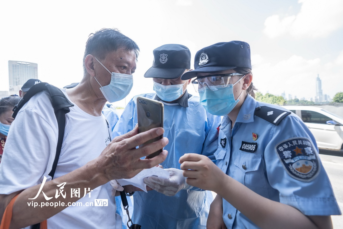 2021年7月22日，南京市南京鐵路警方會同玄武區綜合管理辦公室隊員在南京站進站口對旅客核酸証明和“健康碼”進行檢查。徐成攝（人民圖片網）