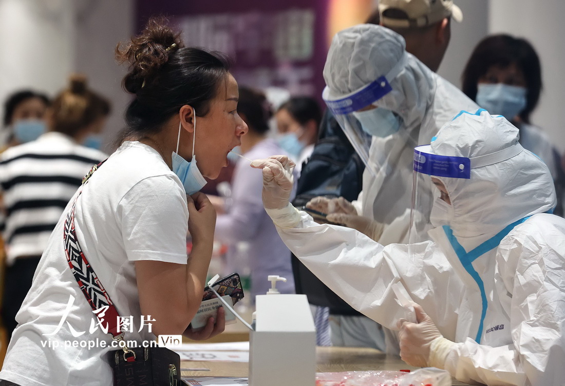 2021年7月21日晚，在南京市秦淮區一處檢測點，醫務人員在為市民進行核酸檢測取樣。辛一攝（人民圖片網）