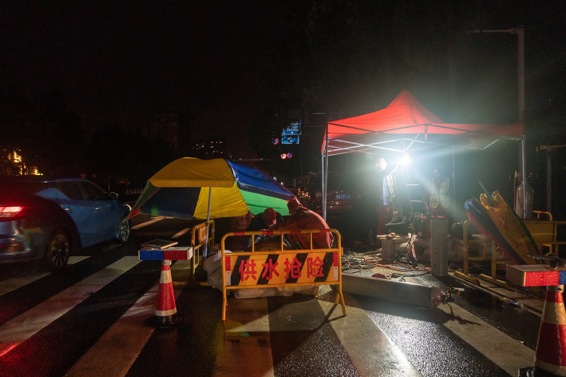 7月22日凌晨，河南省郑州市自来水公司的抢险工人在抢修自来水管道，他们已在此工作近15个小时。新华社记者 才扬 摄