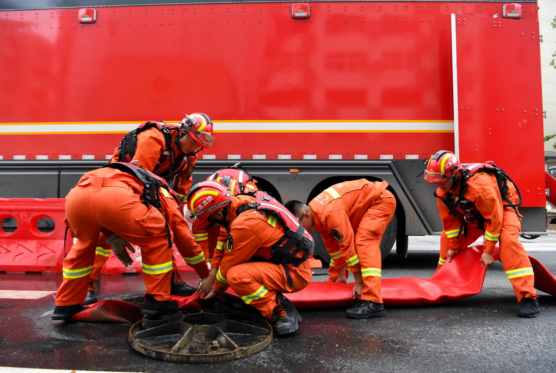 7月21日，消防救援人員在整理排水管道。新華社記者 郝源 攝