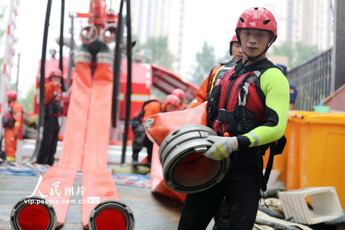 7月23日，在河南省鄭州市中原區一處受災小區，江蘇省揚州市消防救援支隊的消防員進行排澇作業。