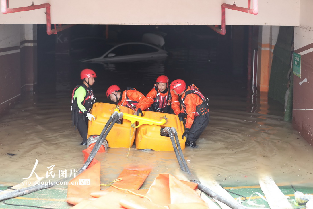 7月23日，在河南省鄭州市中原區一處受災小區，江蘇省揚州市消防救援支隊的消防員進行排澇作業。