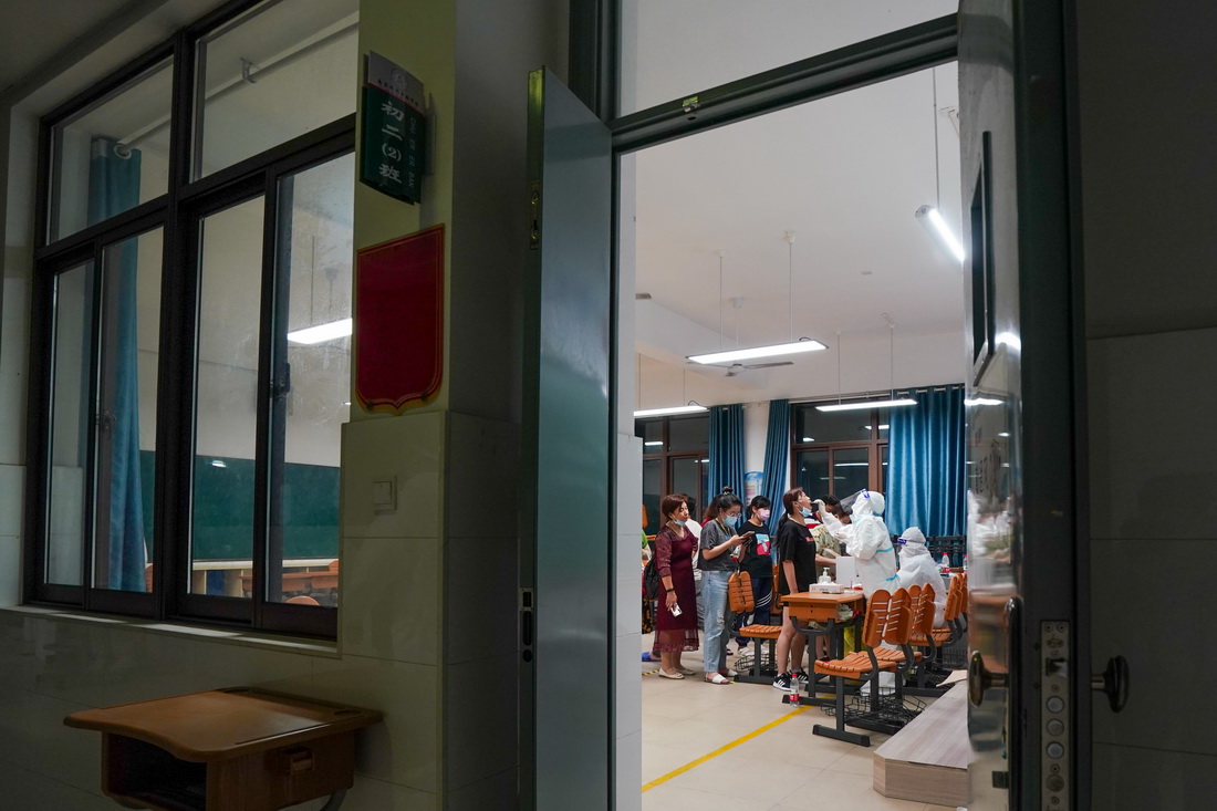 7月24日，醫護人員在南京市江寧區龍西社區核酸檢測點為社區居民進行核酸檢測取樣。新華社記者 李博 攝