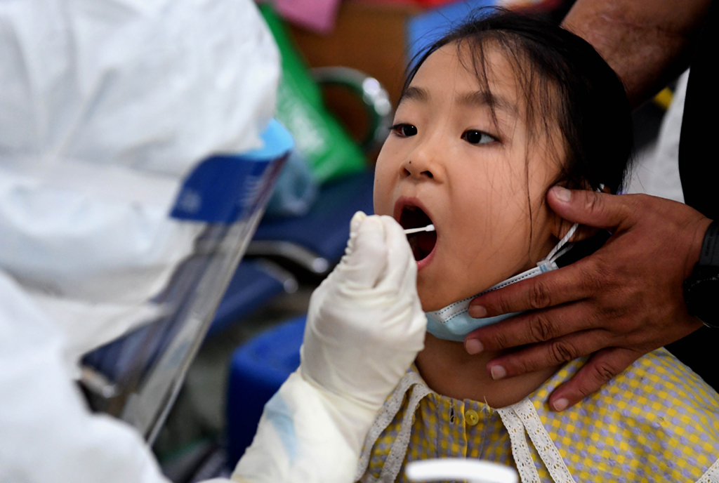 8月1日，在鄭州市二七區的一個核酸檢測點，工作人員對小朋友進行核酸檢測取樣。