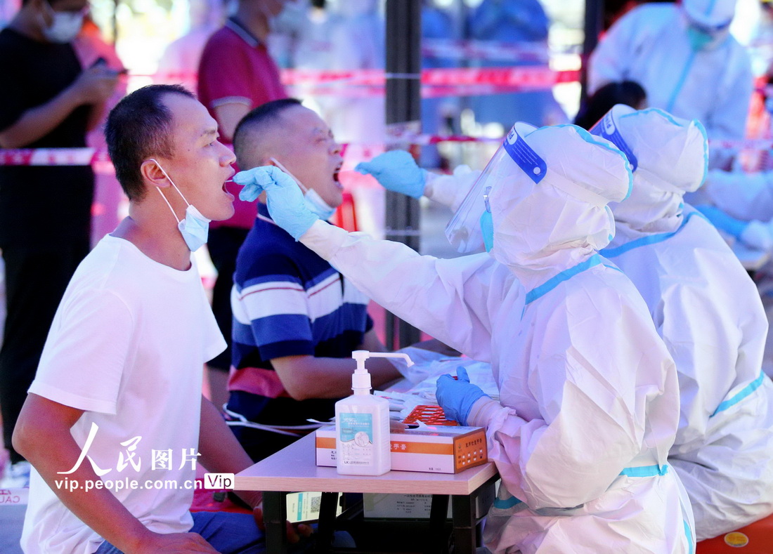 2021年8月4日，在广东省鹤山市鹤山广场，医务人员对市民进行核酸检测取样。