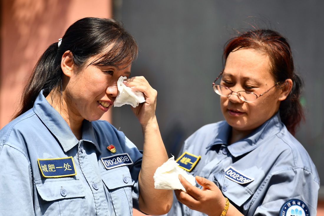 8月4日，济南市城管局城肥清运管理一处女子清疏班杨琳在擦拭汗水。