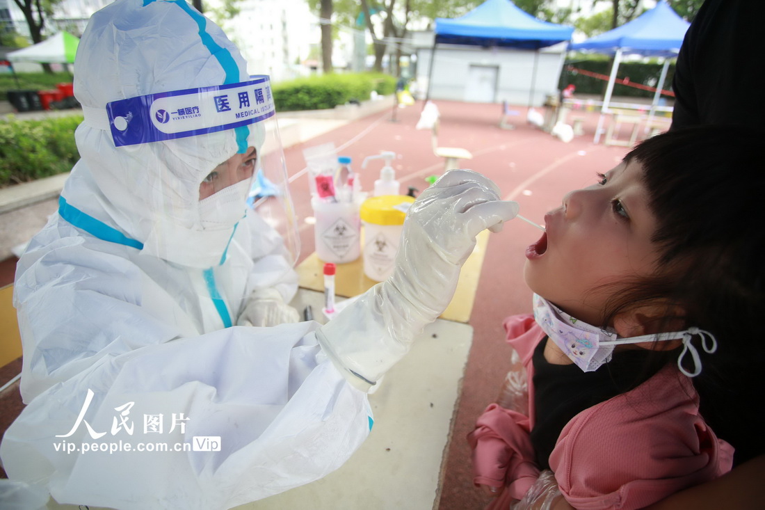 8月5日，在江苏省扬州市育才小学核酸检测点，医务人员为小朋友进行核酸检测采样。