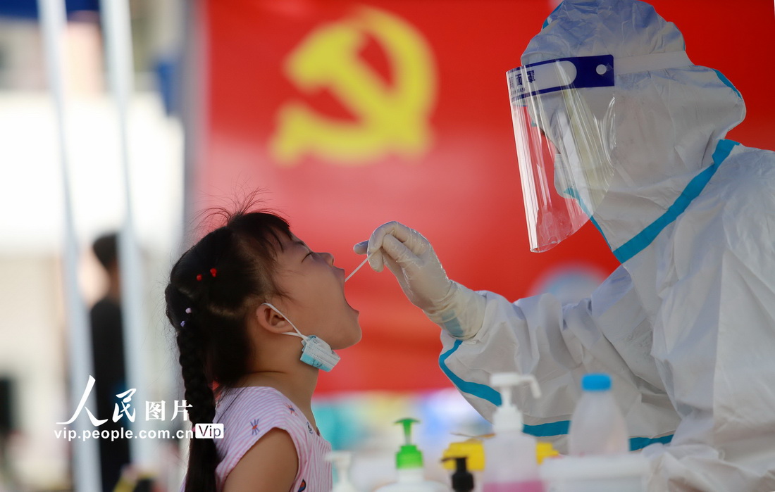 8月5日，在江蘇省揚州市育才小學核酸檢測點，醫務人員為小朋友進行核酸檢測採樣。