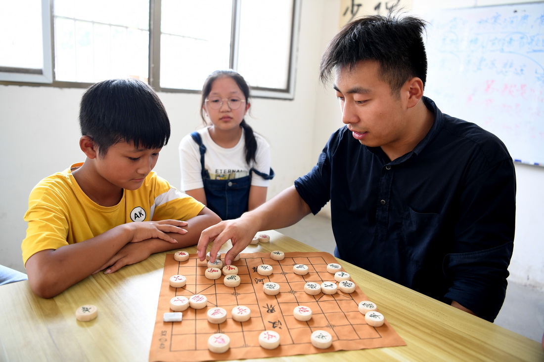 8月3日，周伟杰教孩子们下象棋。新华社记者 黄博涵 摄