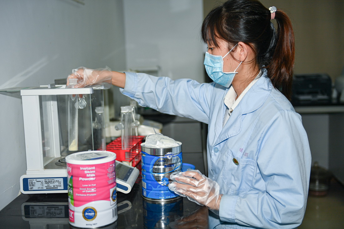 海口海关技术中心工作人员候德莉在实验室对接受检测的离岛免税奶粉进行称样，为后续检测做准备（7月14日摄）。