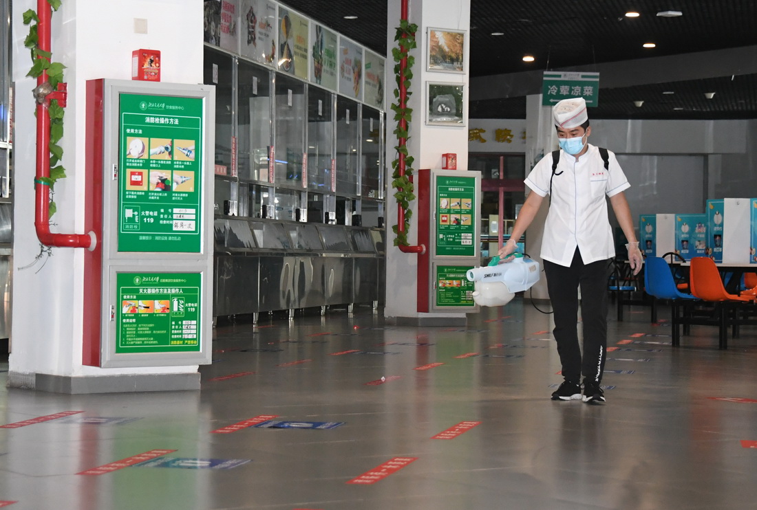 8月9日，在北京交通大学学生第二食堂，工作人员进行消毒作业。
