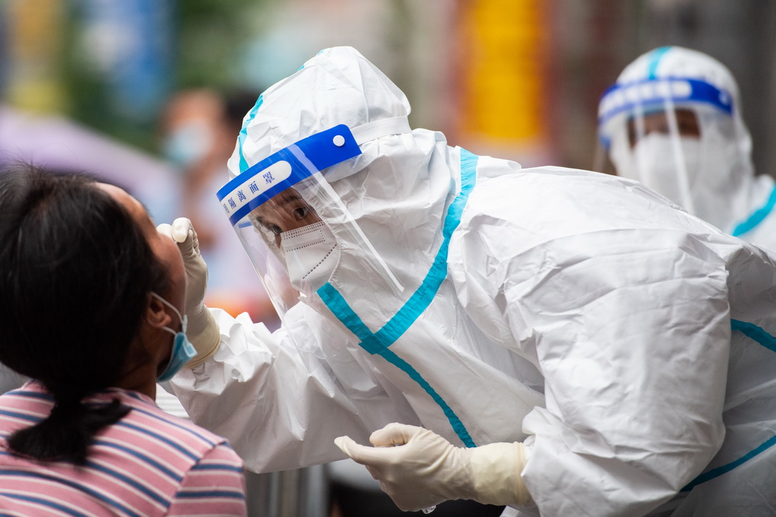 8月10日，在張家界市永定區官黎坪街道，醫務人員給居民做核酸檢測取樣。