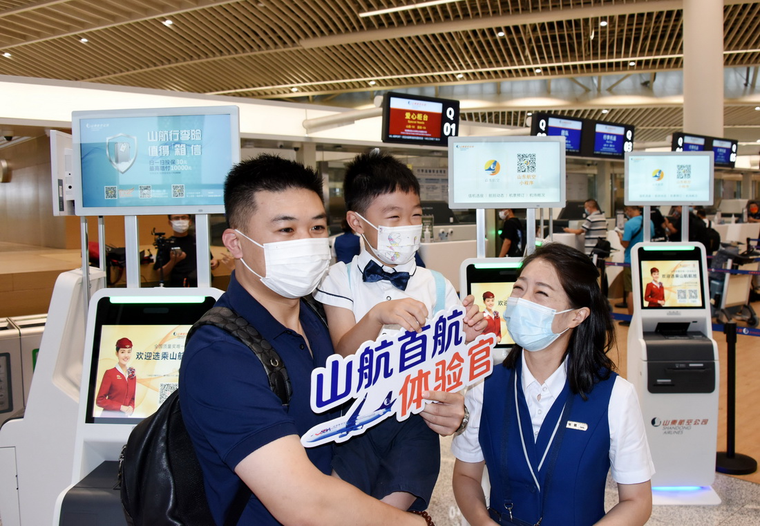 8月12日，首航旅客與航空公司工作人員互動。
