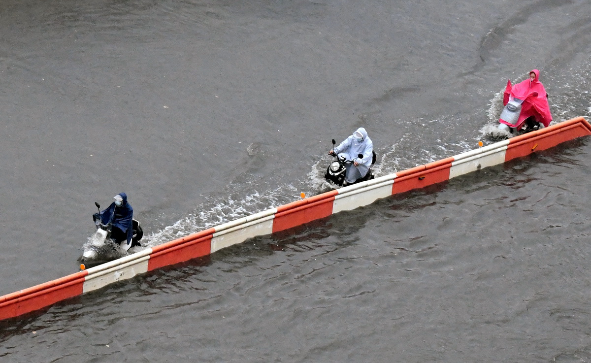 8月22日，市民在鄭州市花園路涉水騎行。新華社記者 朱祥 攝
