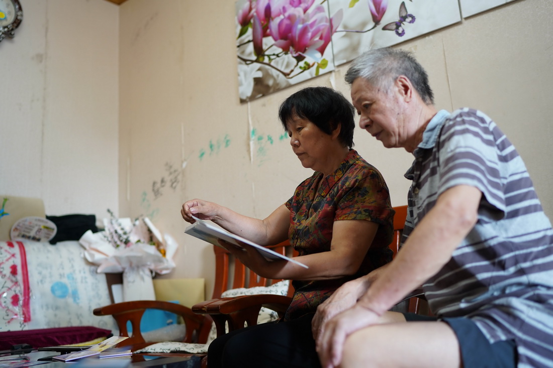 王磊的父母在家中翻看王磊以前的影集（8月23日攝）。新華社記者 周密 攝