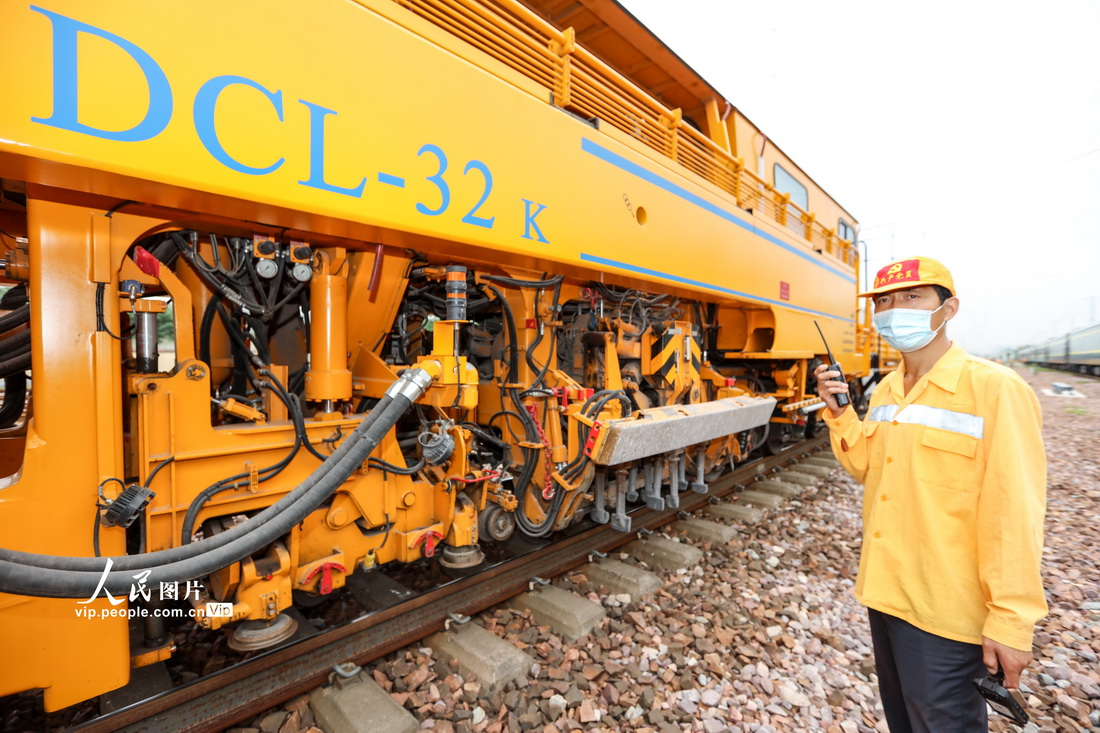2021年8月26日，郑州桥工段工作人员配合现场大型机械整修线路。