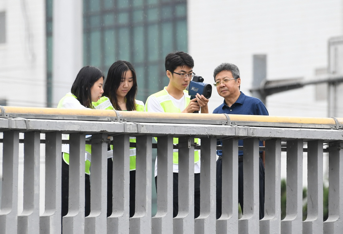 在北京西直门桥，邵春福（右一）与学生们一起数车（8月28日摄）。