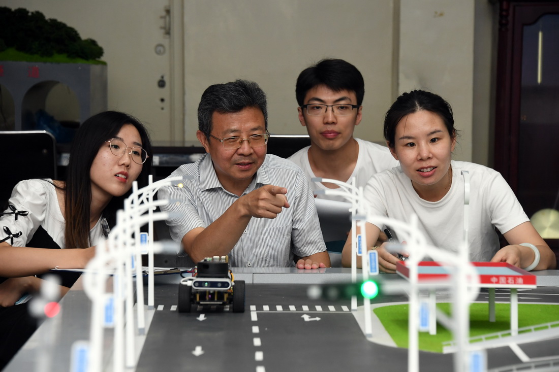 在北京交通大学交通工程实验室，邵春福（左二）与学生们讨论交通调查计划（8月20日摄）。