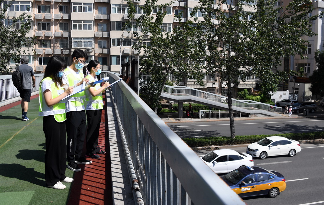 在北京市海淀区联想桥附近的一处天桥，学生们进行交通调查前的踩点工作（8月24日摄）。
