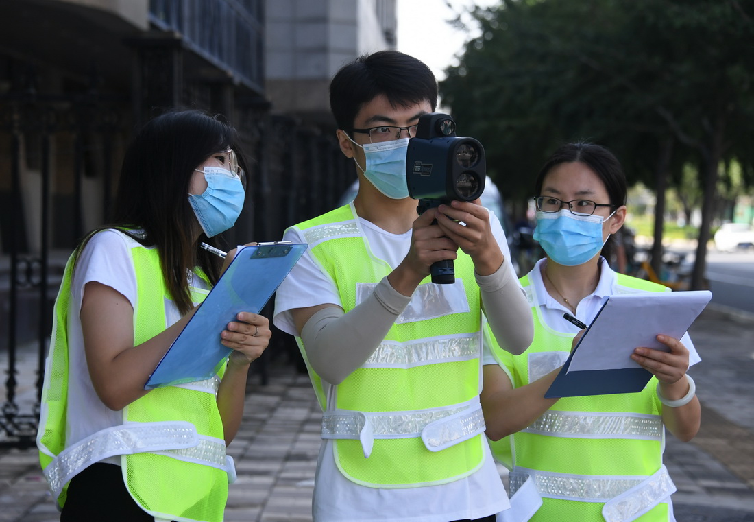 在北京交通大学西门附近的一个十字路口，学生们在踩点过程中使用雷达枪测量车速（8月24日摄）。