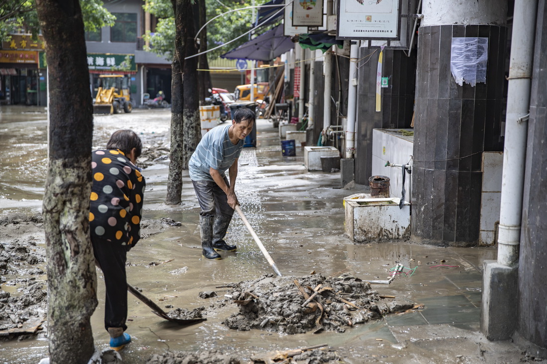 8月30日，在重庆市巫溪县宁河街道漫滩路，人们在清淤。