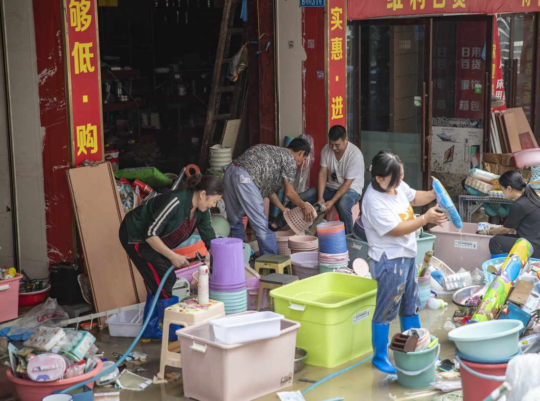 8月30日，在重庆市巫溪县宁河街道裕宁街，商户清理被洪水泡过的物品。