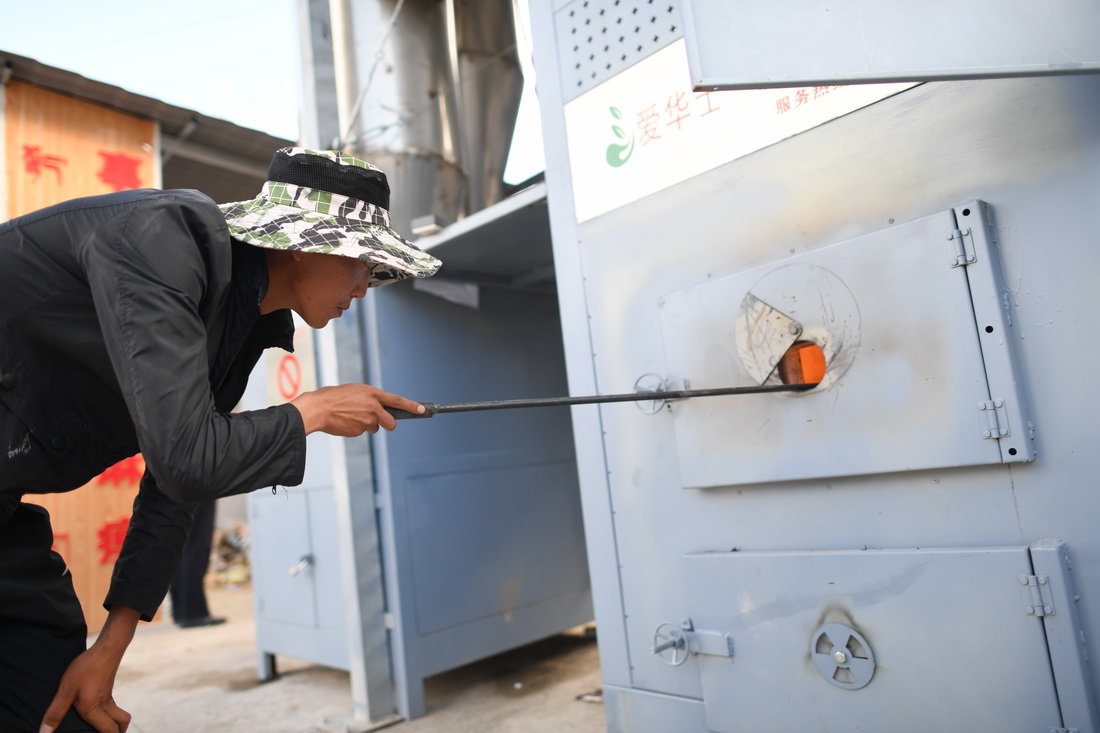9月1日，在扎毛村垃圾焚烧场，一名工作人员检查垃圾焚烧情况。