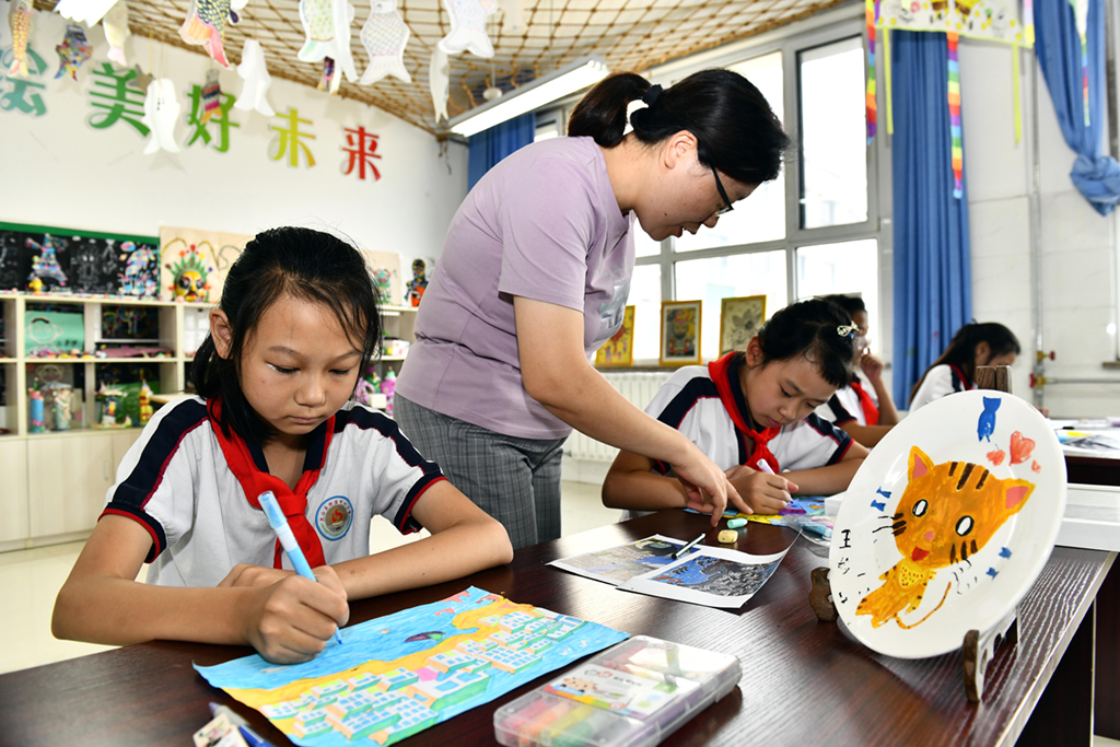 9月3日，在日照市岚山区岚山头小学，学生们在老师指导下学习画画。