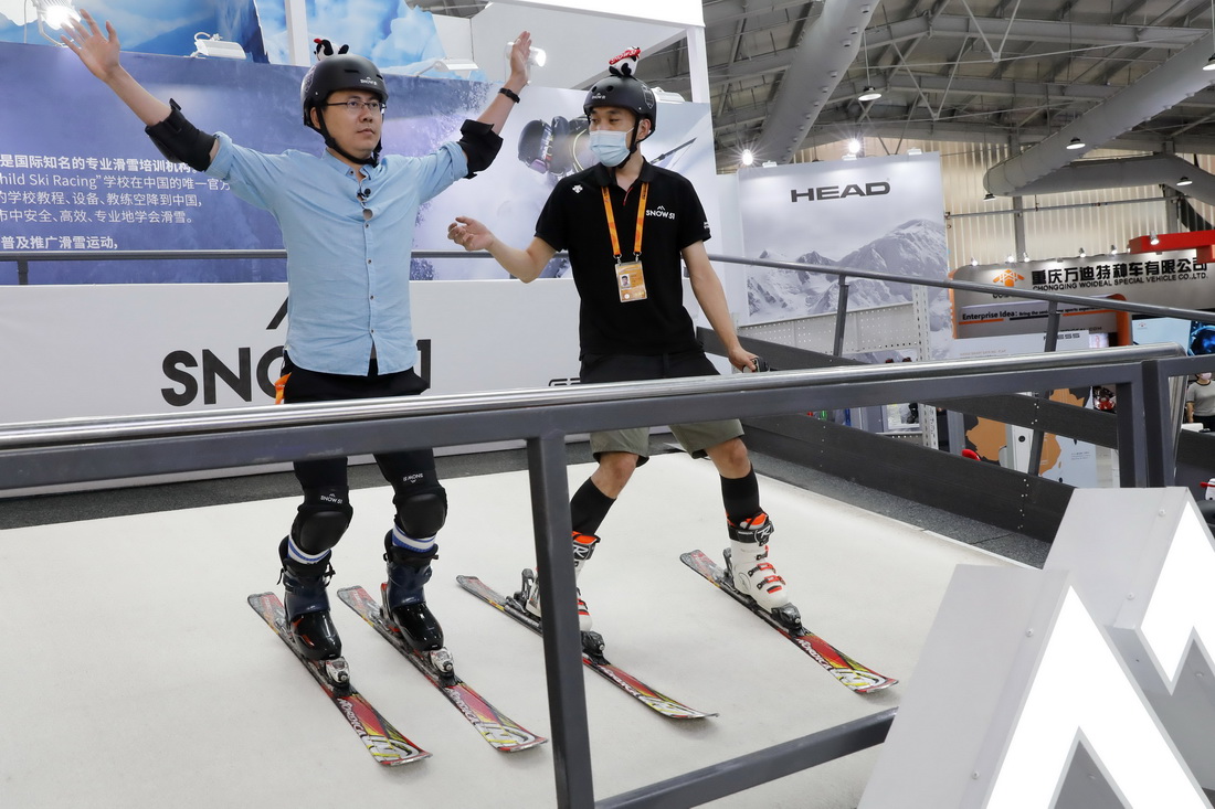 9月4日，一名參會人員（左）在服貿會首鋼園區體育服務展館體驗滑雪模擬設備。新華社記者 張玉薇 攝