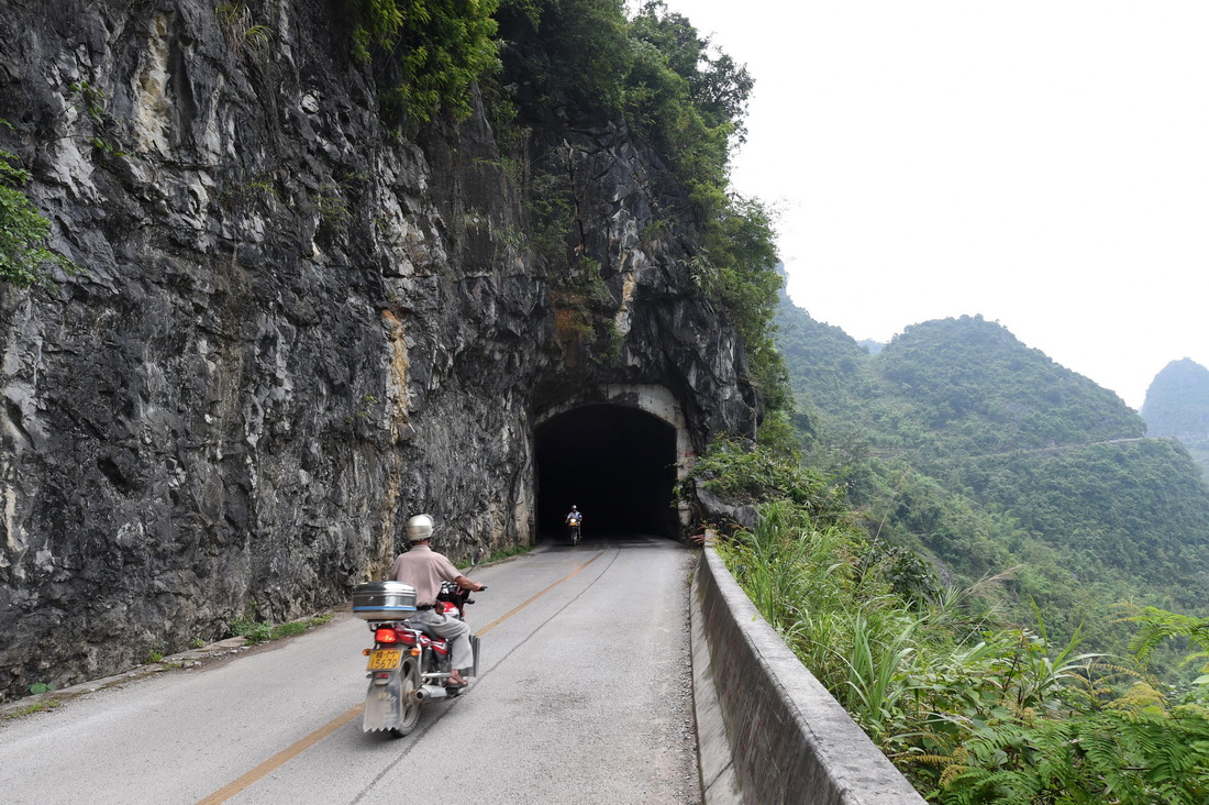 村民騎行穿越廣西都安瑤族自治縣澄江鎮境內的一處山區公路隧道（2015年7月2日攝）。新華社記者 陸波岸 攝
