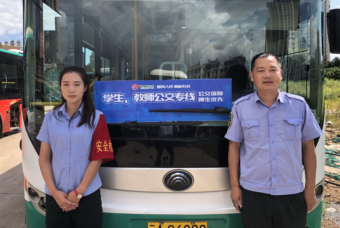 9月6日，武艷夢（左）和楊文剛在兩人負責的校園公交專線公交車前合影（受訪者供圖）。
