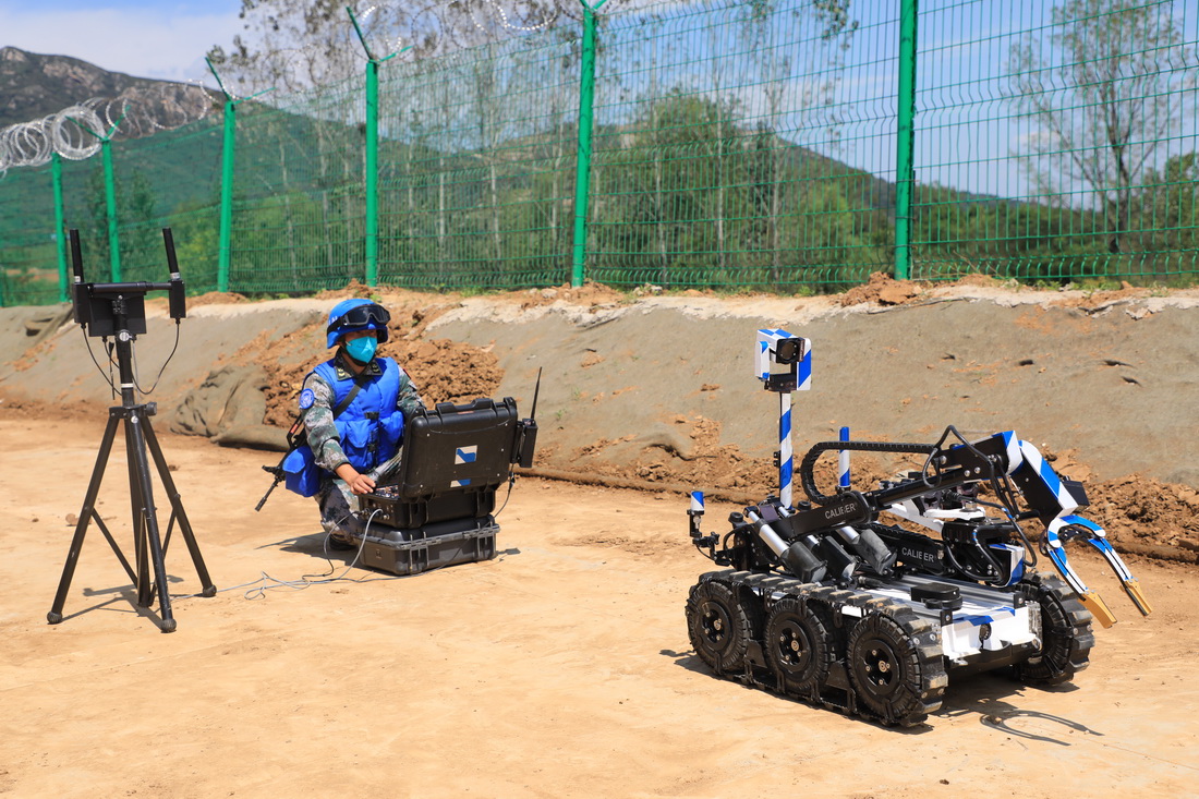 9月8日，在“共同命運-2021”國際維和實兵演習專業分訓中，參演官兵利用排爆機器人進行排爆作業。