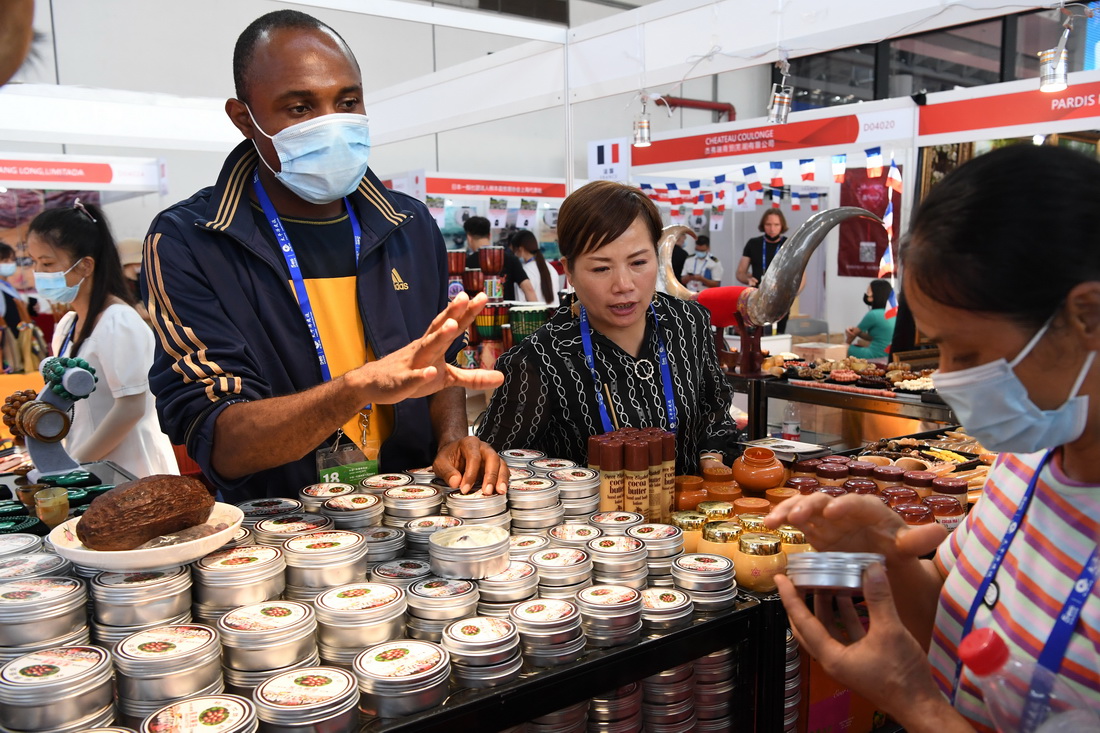 9月11日，来自加纳的参展商向参观者介绍加纳的乳木果油。新华社记者 马宁 摄