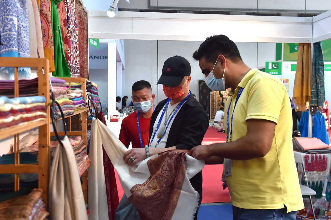 9月12日，在广西南宁国际会展中心，穆扎法尔・艾哈迈德・巴特向参观者介绍巴基斯坦商品。新华社记者 刘岭逸 摄