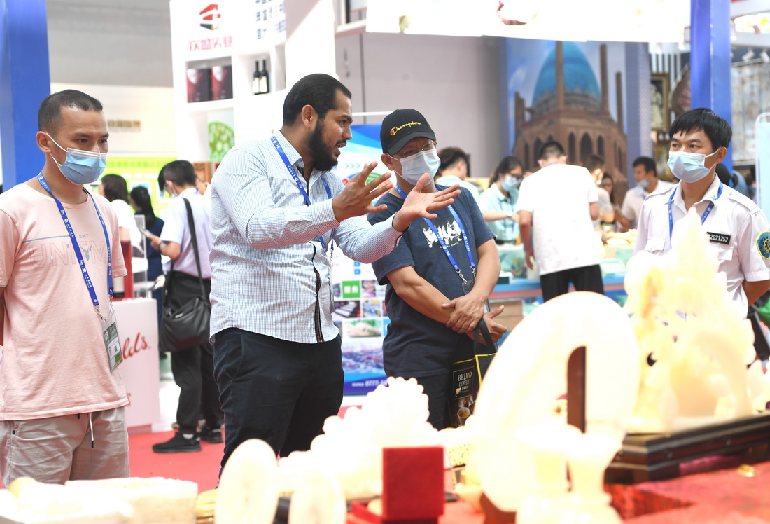 9月12日，参展商卡米（左二）在广西南宁国际会展中心向参观者介绍巴基斯坦工艺品。新华社记者 周华 摄