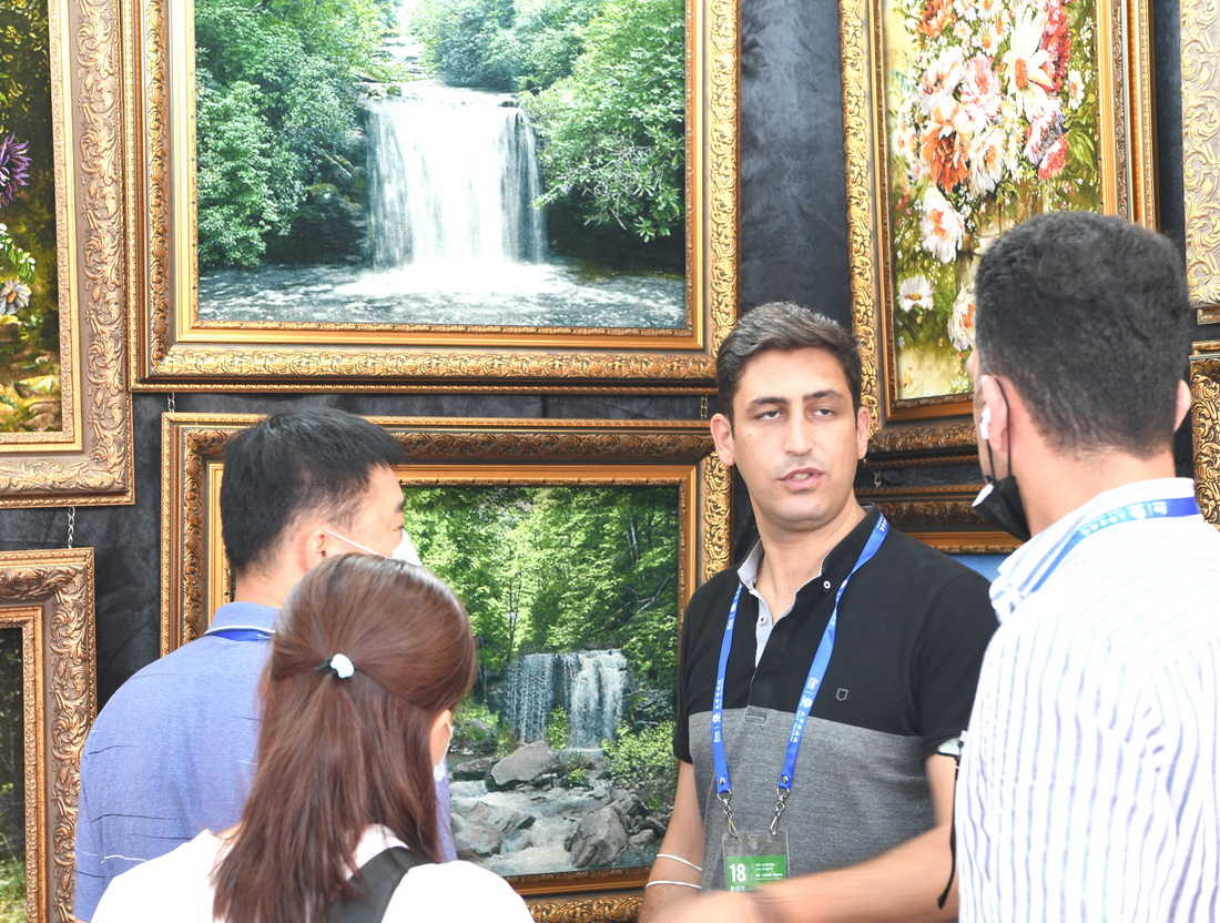 9月12日，参展商艾博（右二）在广西南宁国际会展中心向参观者介绍伊朗工艺品。新华社记者 周华 摄