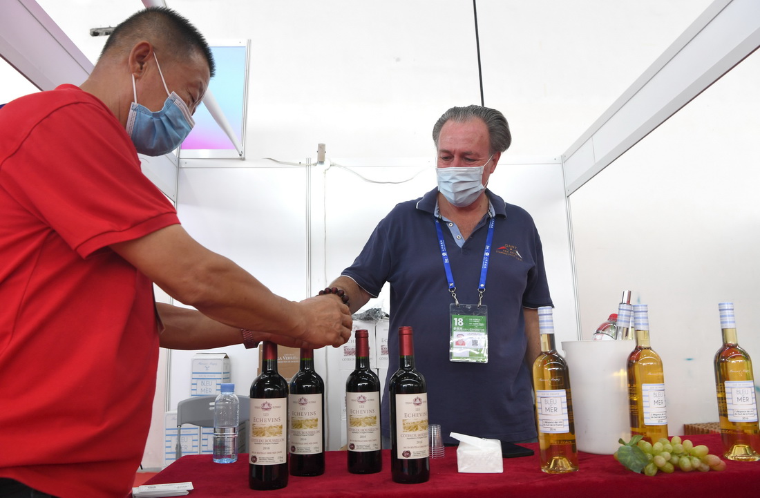 9月12日，法国参展商（右）在广西南宁国际会展中心向参观者推介红酒。新华社记者 周华 摄