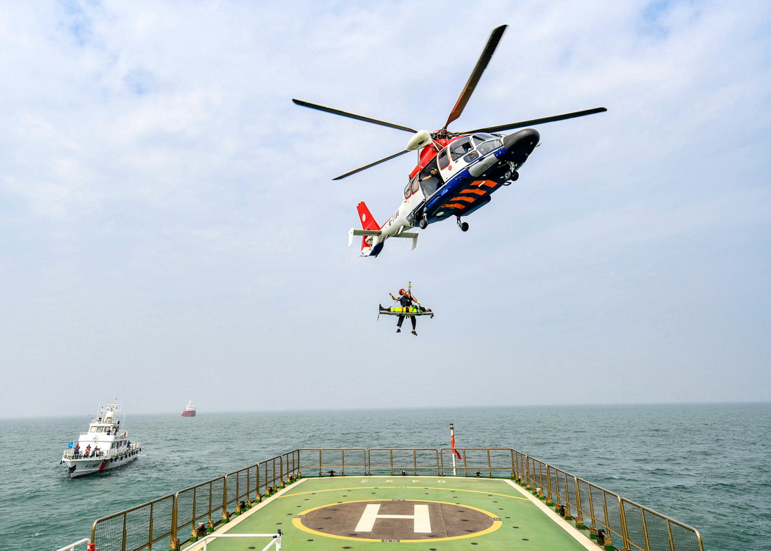 9月13日，在河北曹妃甸海域，救助直升機救生員模擬轉移獲救落水人員。
