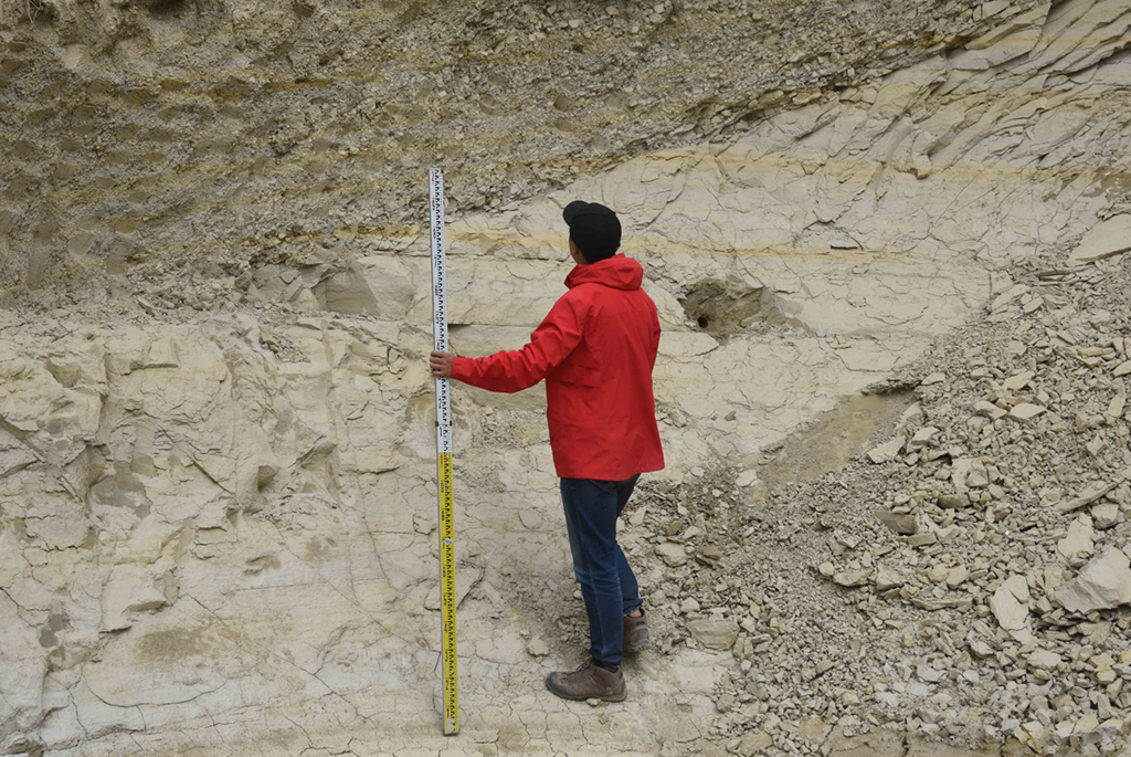 8月27日，在西藏日喀则市定结县一处山体，科考队员郭剑使用标尺，测量湖相沉积物厚度。新华社记者 杜刚 摄
