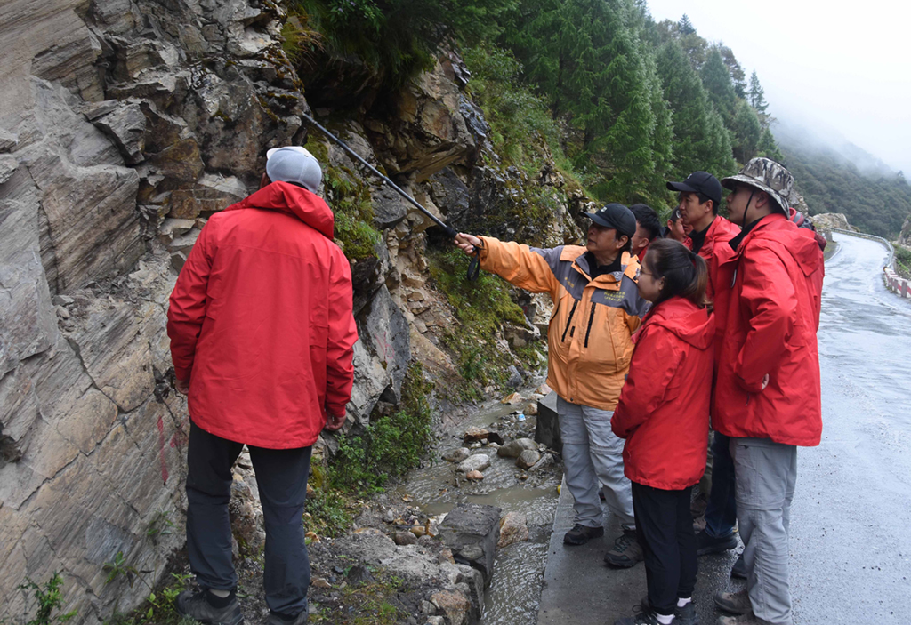 9月7日，在西藏日喀则市一处山体，中科院地理科学与资源研究所客座教授李渝生（左二）和年轻的科考队员分析地质灾害问题。新华社记者 杜刚 摄