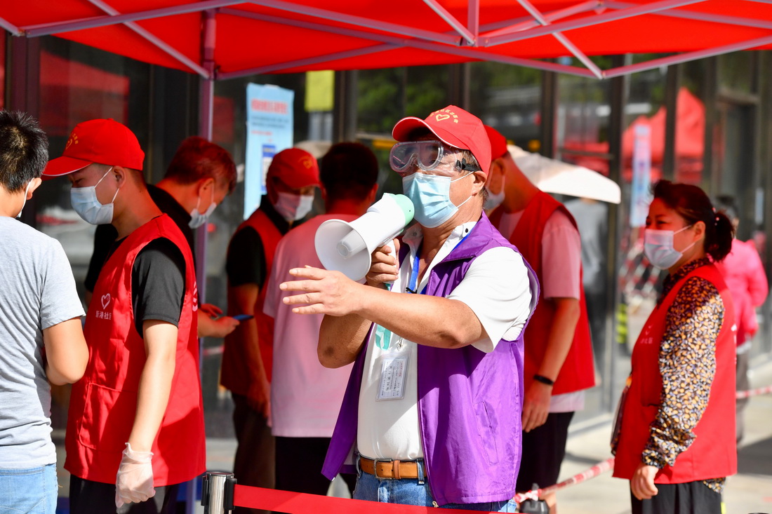 9月22日，在廈門思明區一核酸檢測點，台胞志願者毛維林（前）在引導市民排隊進行核酸取樣。